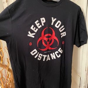 Graphic T, “ KEEP YOUR DISTANCE “ and “;DONT TREAD NEAR ME” on the back.